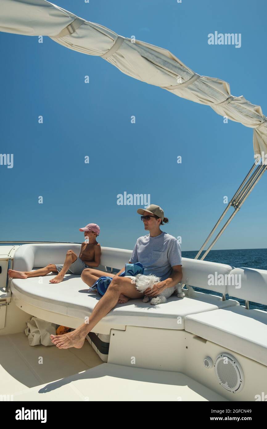 Two brothers of different ages sail on a luxury yacht. Rest on a yacht Stock Photo
