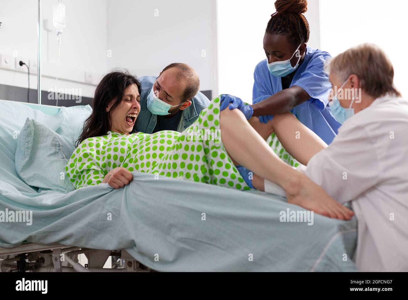 https://c8.alamy.com/comp/2GFCNG7/pregnant-woman-in-painful-labor-giving-birth-to-child-at-maternity-clinic-obstetrician-and-black-nurse-assisting-childbirth-and-helping-young-mother-with-delivery-in-hospital-ward-2GFCNG7.jpg