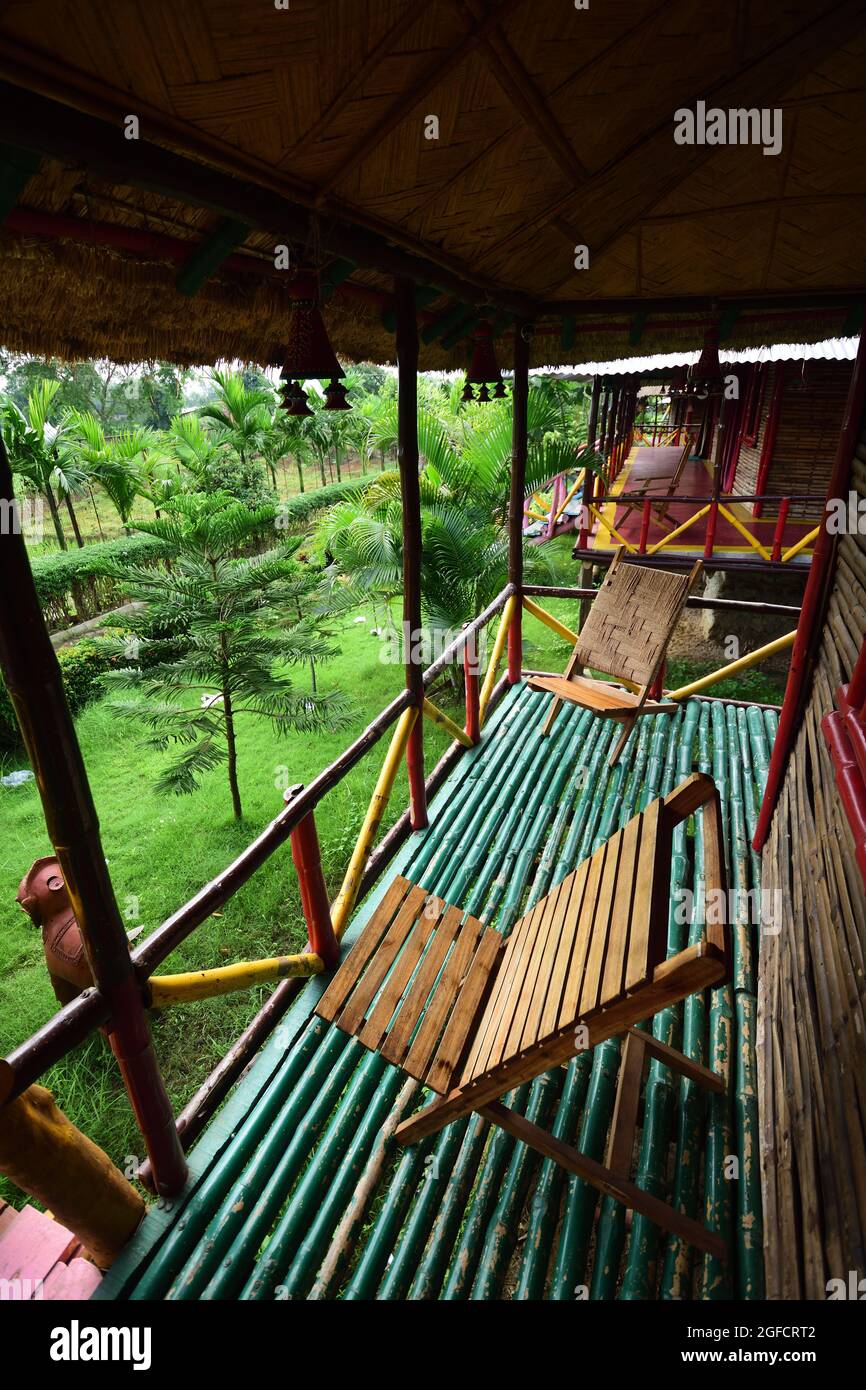 Empty easy chairs in thatched cottage veranda of a resort at Joipur Forest. Bankura, West Bengal. India. Stock Photo