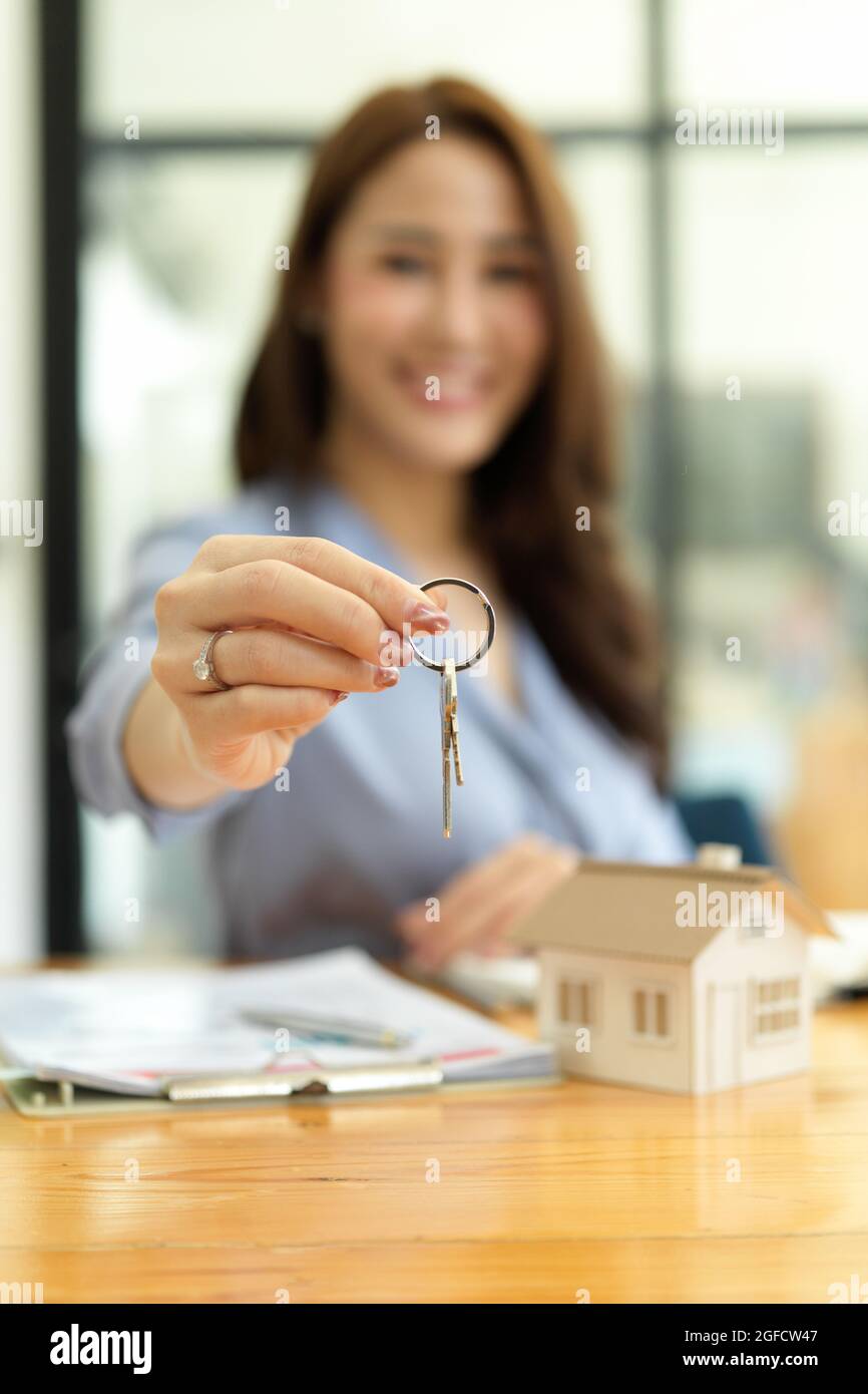 Focused hands, Beautiful real estate agent holding house key, house