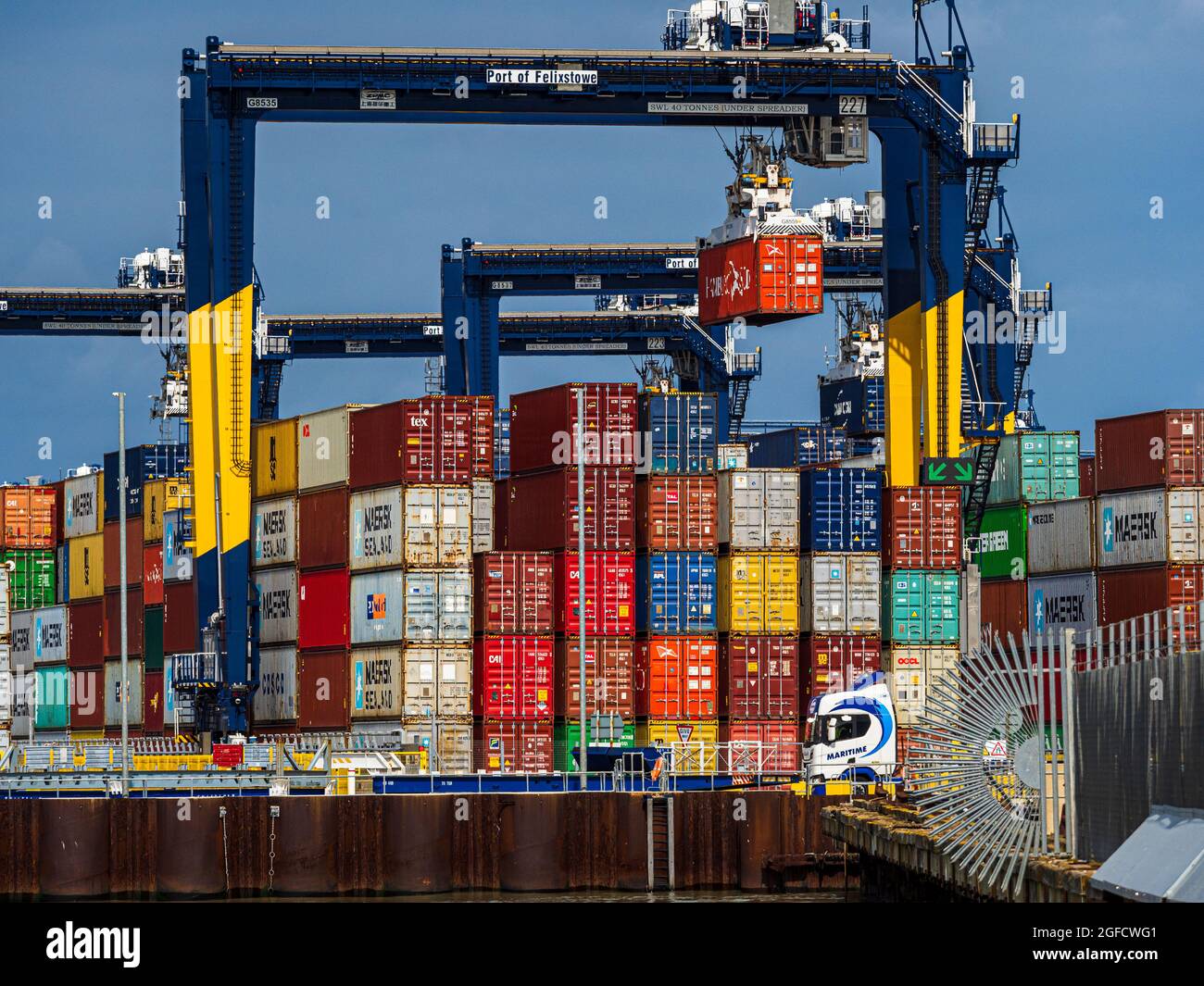 Global Supply Chains - Containers stacked on the dockside at the Port of Felixstowe UK. Global Supply Chain Congestion. Stock Photo