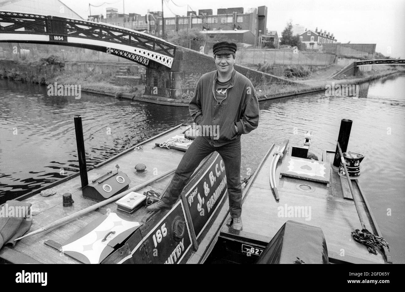 Astride two narrow boats in the Birmingham canals actor Michael Elphick as BOON the leading character for the Central TV series BOON in 1985 takes time of from filming to enjoy the life on canal craft. Stock Photo