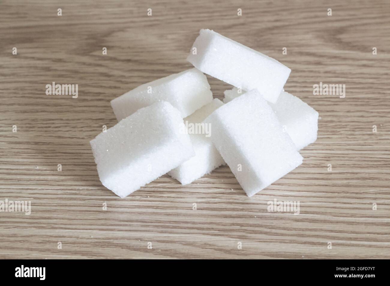 Heap of sugar cubes on wooden background Stock Photo - Alamy