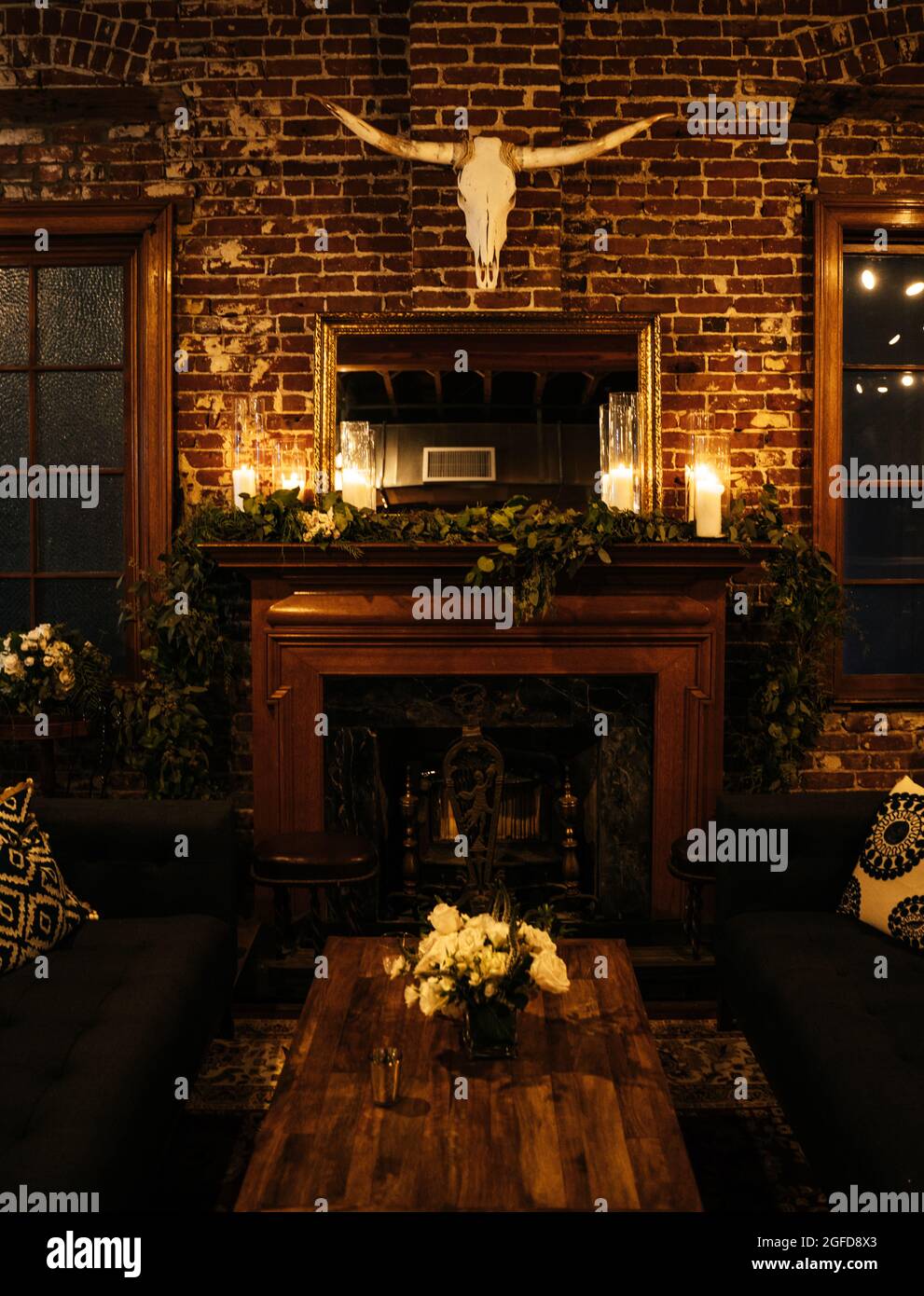 Vertical shot of a brick room with a fireplace and a bull skull over Stock Photo
