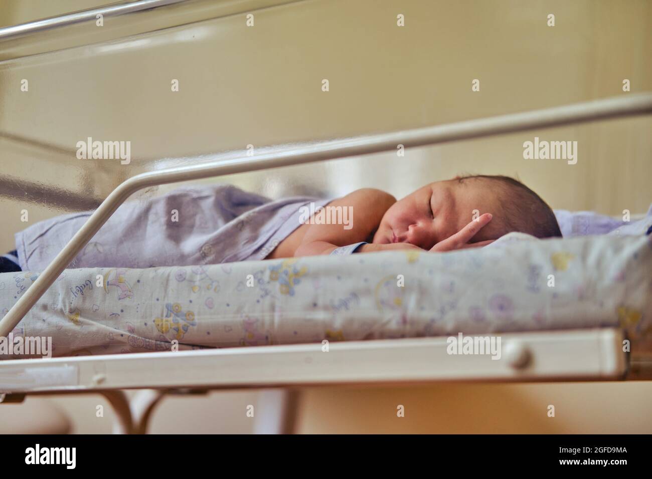 A newborn baby with a maternity hospital bracelet on his arm is