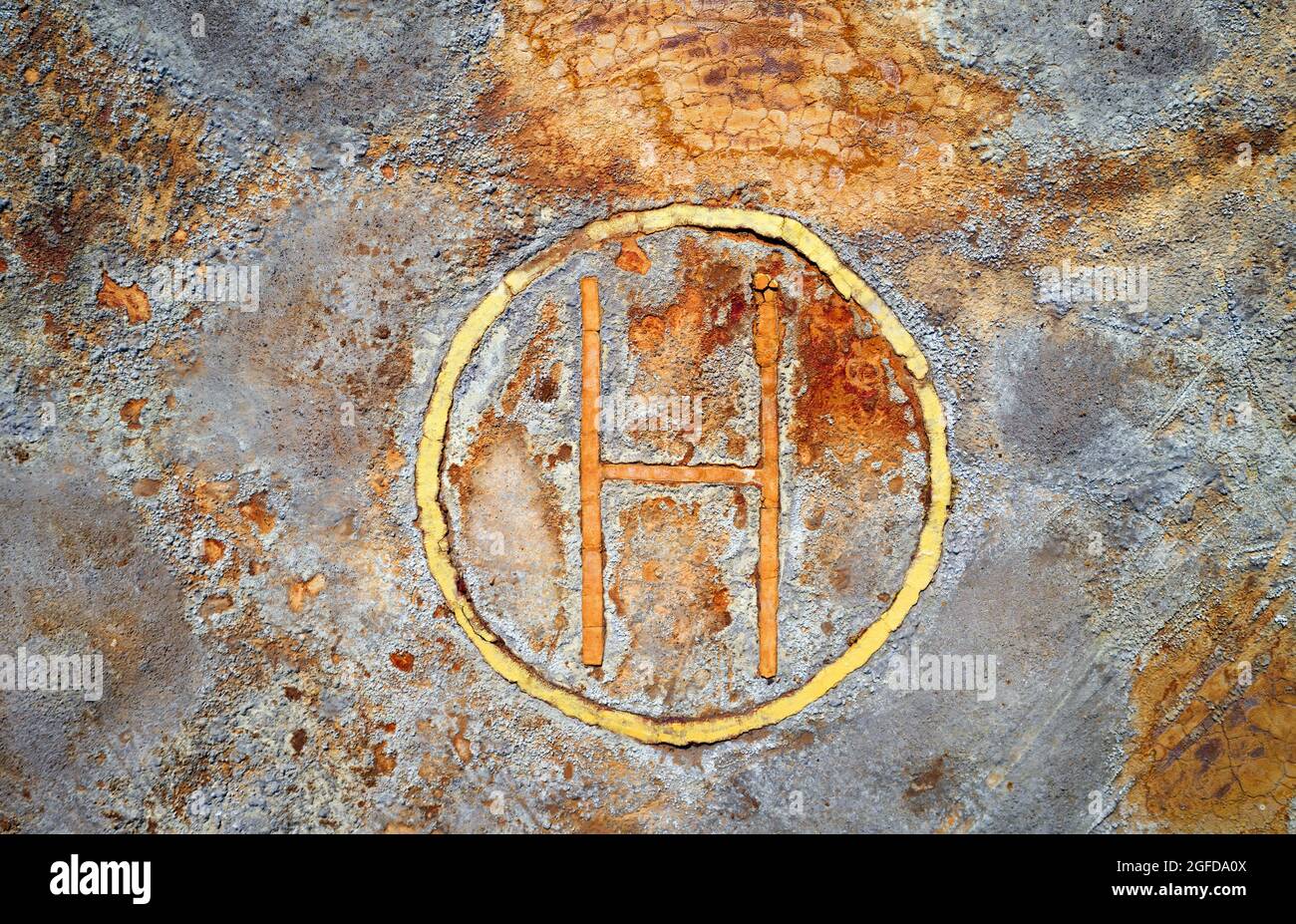 Rusty helipad at abandoned mine over rough stone surface, aerial view directly above. Dystopic post apocalyptic texture Stock Photo