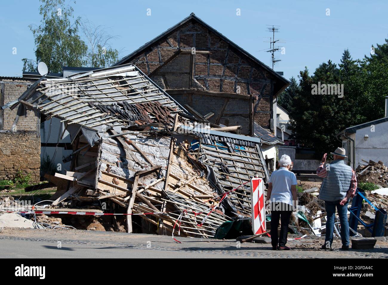 25 August 2021, North Rhine-Westphalia, Bad Münstereifel: Residents stand in front of damaged houses. The flood disaster in mid-July has so far caused insurance losses of around seven billion euros, which is more than previously expected. According to the industry association GDV, 6.5 billion euros of this was attributable to residential buildings, household contents and businesses, and around 450 million euros to motor vehicles. Photo: Federico Gambarini/dpa Stock Photo