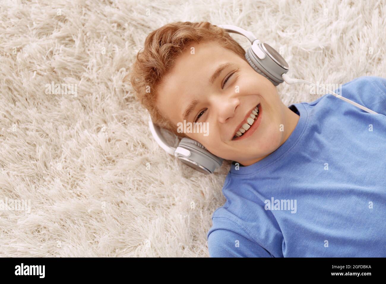 Boy listening music on carpet Stock Photo - Alamy