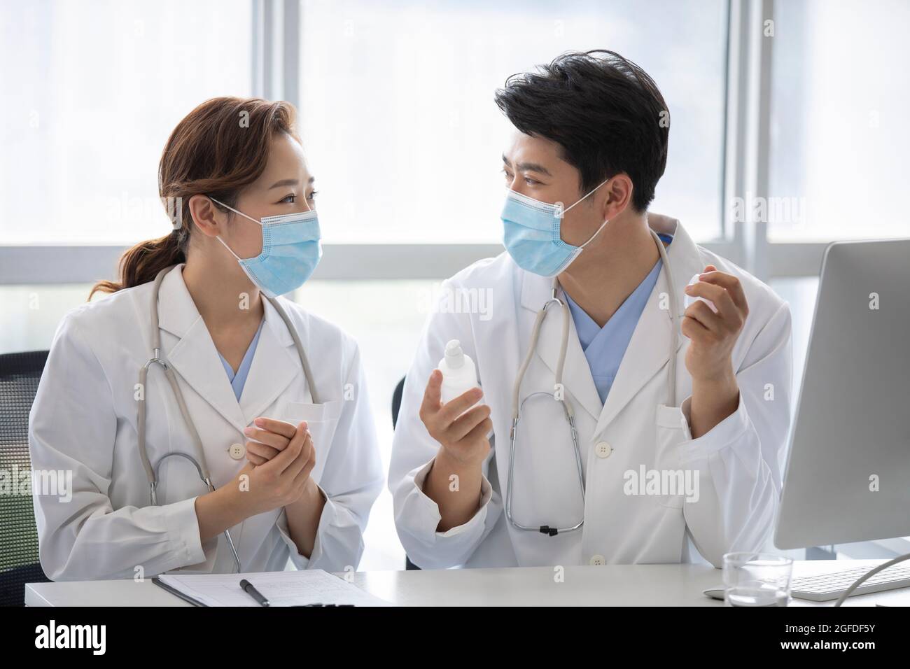 Young doctors using hand sanitizer in doctor's office Stock Photo