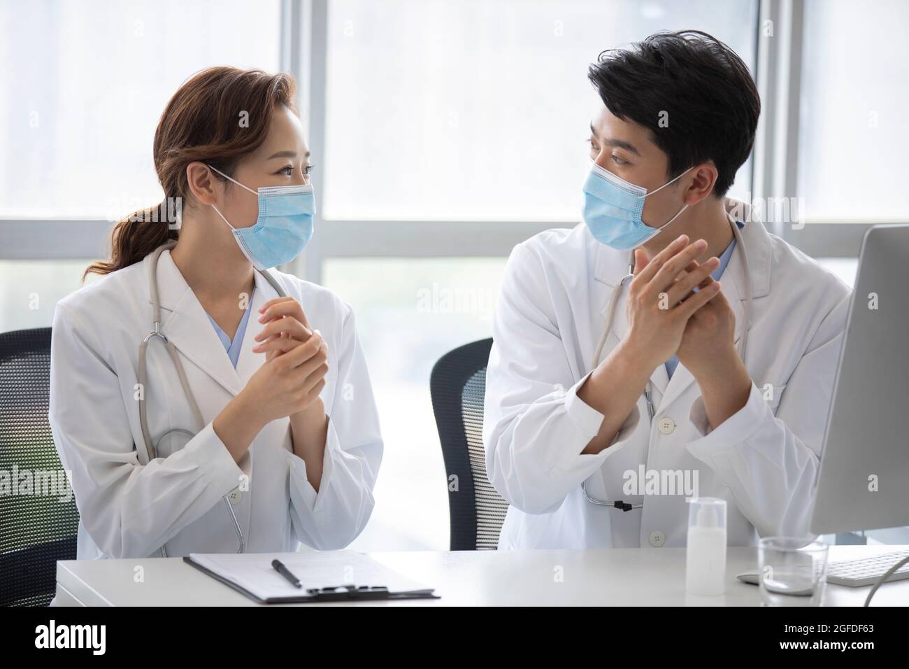 Young doctors using hand sanitizer in doctor's office Stock Photo