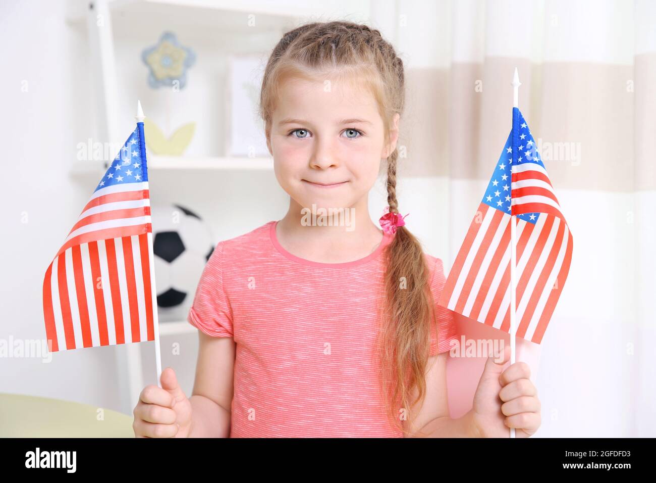 Cute little girl holding American flags in kindergarten Stock Photo - Alamy