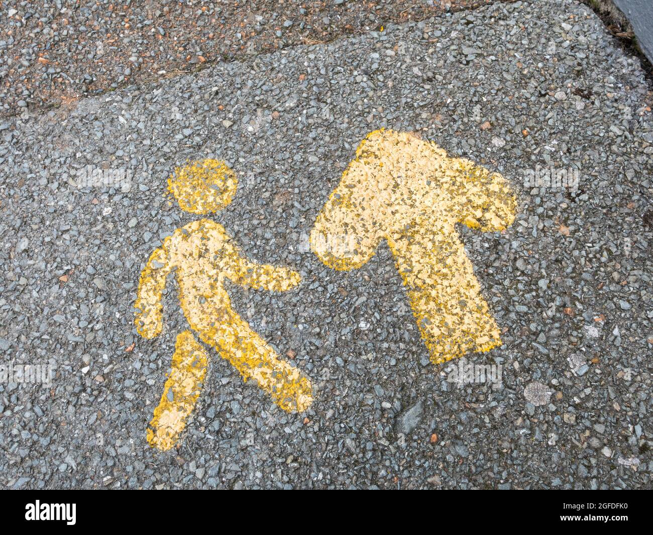 Small stencilled pavement markings pointing out the direction of footfall. Seen in St. Austell, Cornwall. For retail foorptint, directions. Stock Photo