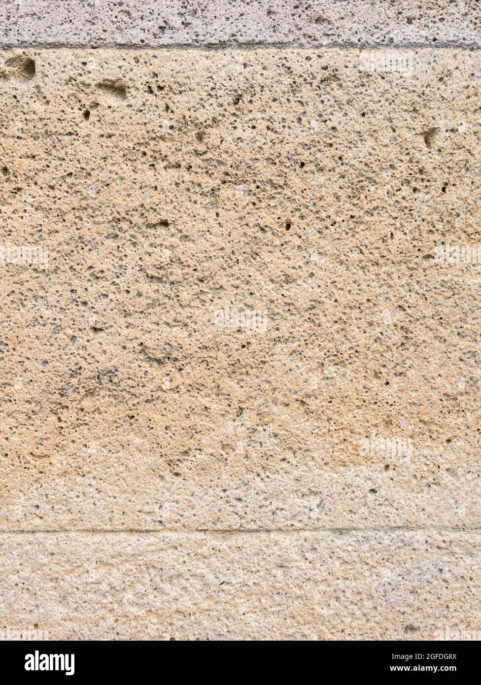 Close-up shot of weathered yellowy sandstone which almost has a sponge or sponge-like texture. For ageing stonework,decaying stonework. Stock Photo