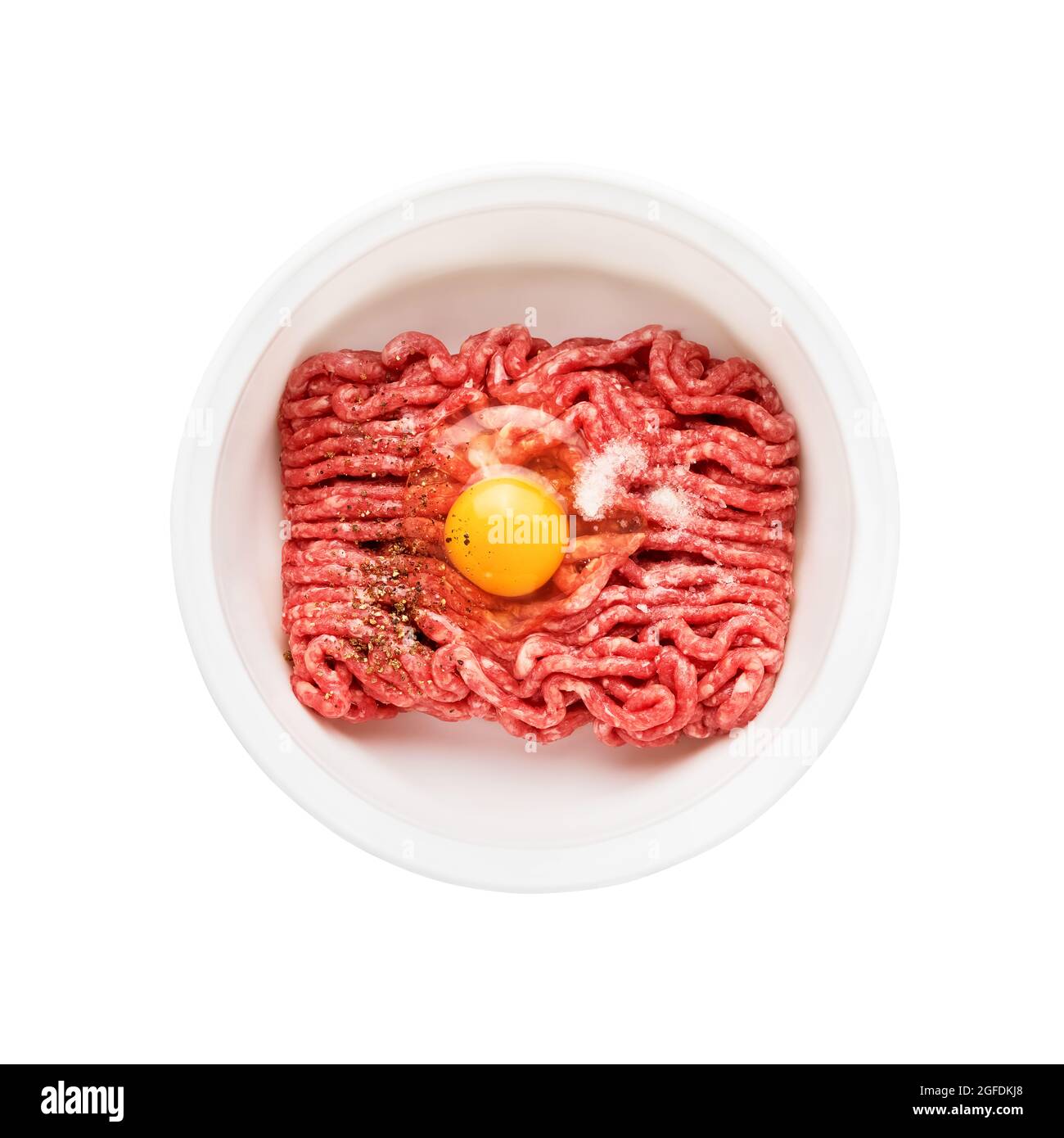 Raw ground beef, minced beef with egg and salt in a bowl isolated over white background. Top view Stock Photo