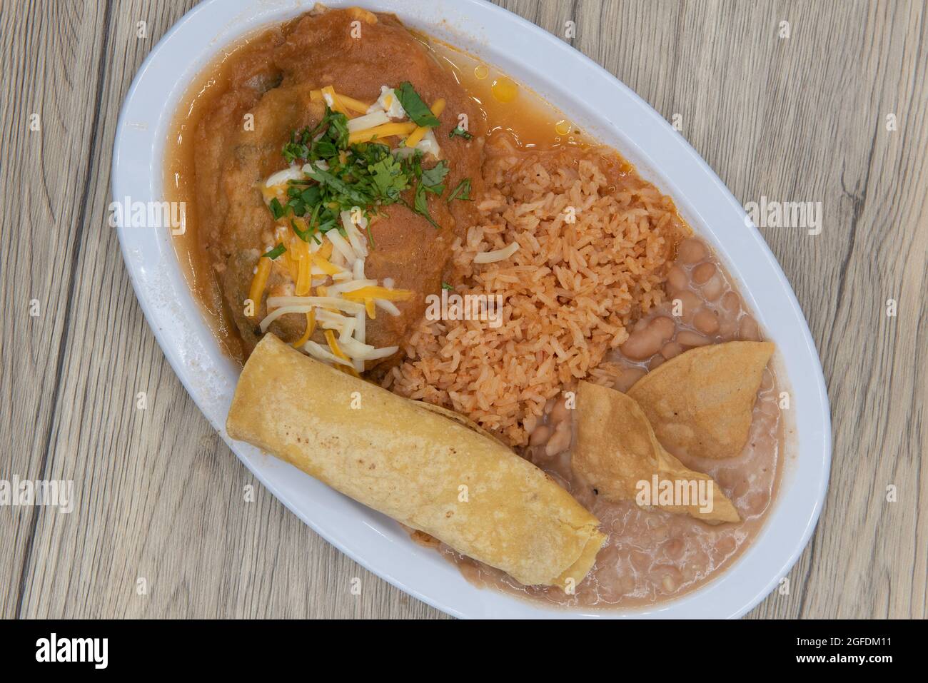 Overhead view of hearty plate of chili relleno smothered in wet sauce served with rice and