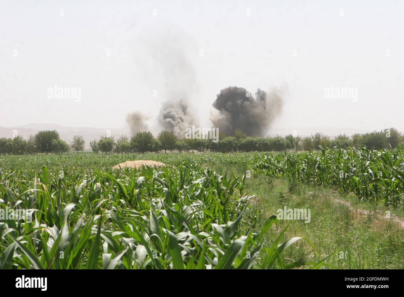 Rounds from a high-mobility artillery rocket system and a B-1 bomber detonate on insurgent positions in support of the Marines on the ground with Company E, 2nd Battalion, 8th Marine Regiment, here Aug. 13. Stock Photo