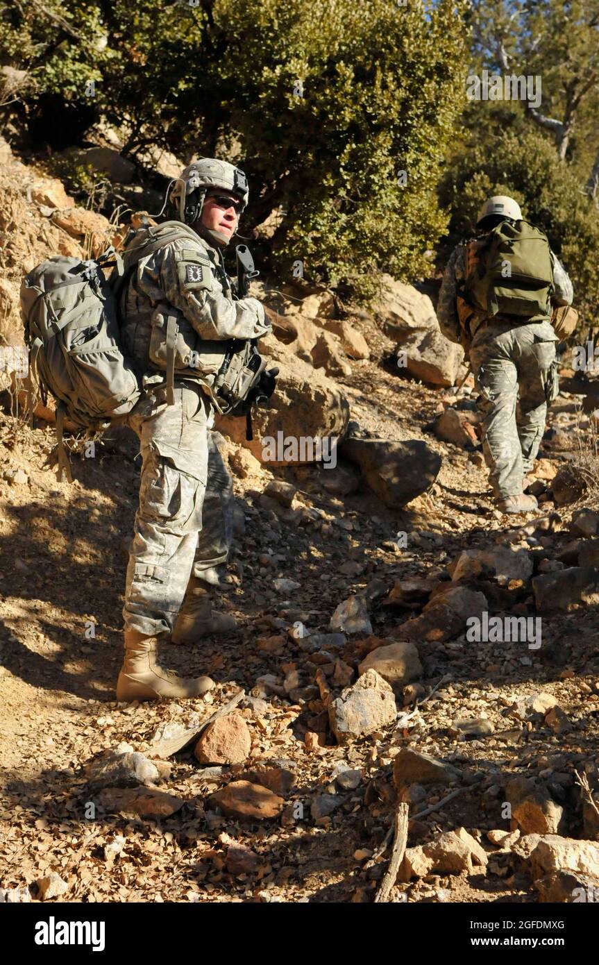 U.S. Army Staff Sgt. Dennis Speek, 707th Explosive Ordnance Disposal team leader, Fort Lewis, Wash., patrols up a mountain en-route to destroy the 'Taliban Hotel,' a safehouse utilized by insurgent fighters infiltrating Afghanistan in the vicinity of Combat Outpost Spera, Khost province, Dec. 18. The EOD team partnered with soldiers from the 1-40th Cavalry (Airborne), Fort Richardson, Alaska, and Afghan national security forces to level the safehouse. Stock Photo