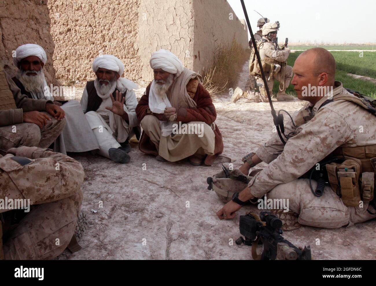 Capt. Stephan P. Karabin, commanding officer, Charlie Company, 1st Battalion, 3rd Marine Regiment, makes first contact with three village elders from the Five Points area during a patrol Feb. 14.  Marines had been previously unable to meet with local leaders due to engagements with Taliban fighters during their patrols.  Karabin, 30, is from West Palm Beach, Fla. Stock Photo