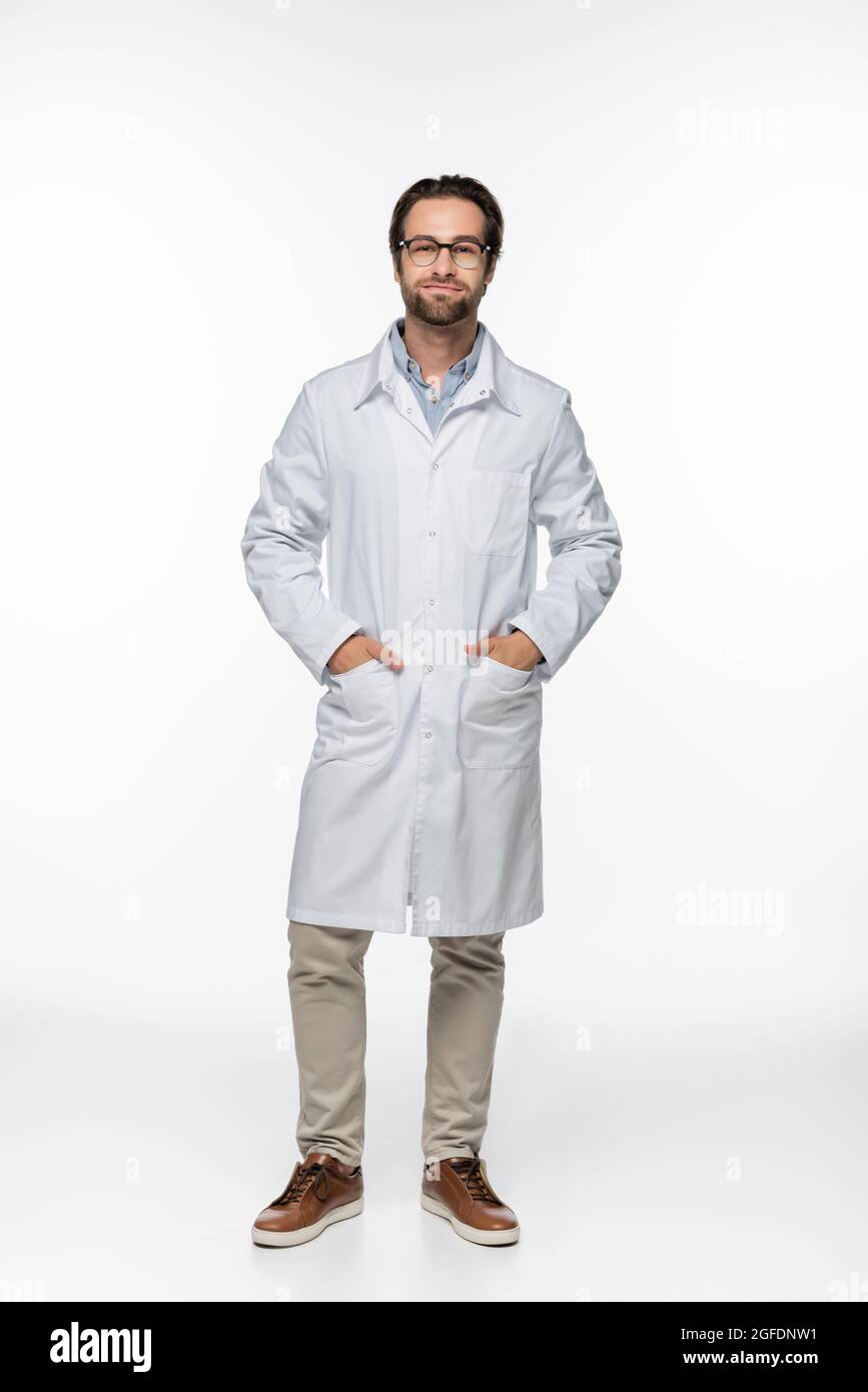 Doctor in eyeglasses and coat looking at camera on white background ...