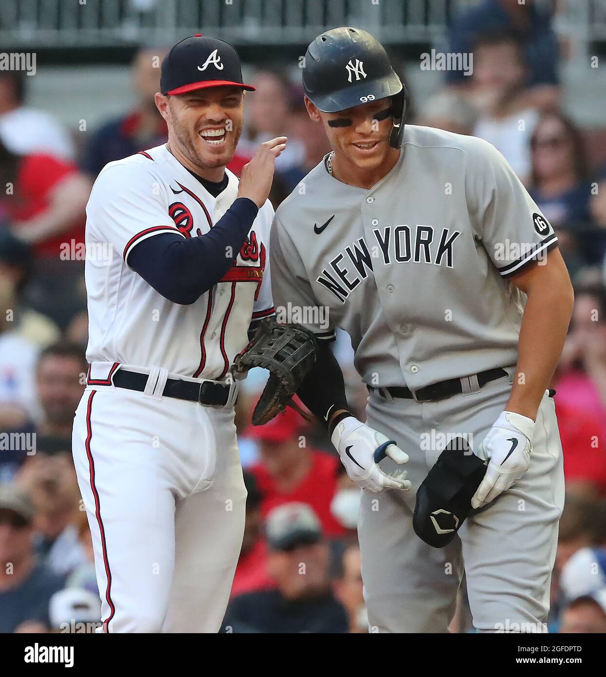 Atlanta Braves first baseman Freddie Freeman and New York Yankees  outfielder Aaron Judge share a laugh at first base with Freeman giving him  a pat on the shoulder after Judge hit a