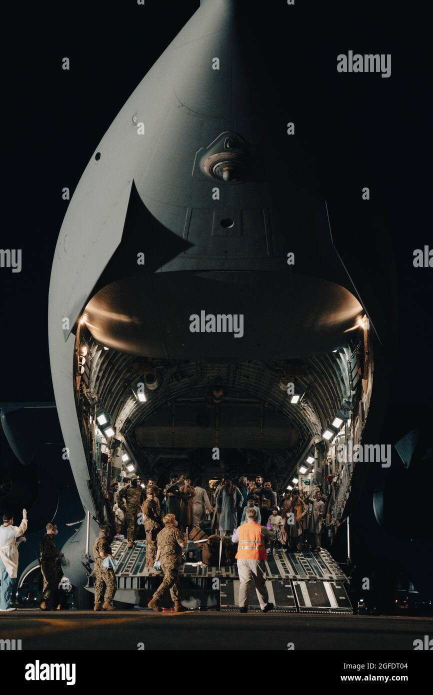 Afghanistan evacuees depart a U.S. Air Force C-17 Globemaster lll at Naval Air Station Sigonella, Aug. 22, 2021. NAS Sigonella is currently supporting the Department of Defense mission to facilitate the safe departure and relocation of U.S. citizens, Special Immigration Visa recipients, and vulnerable Afghan populations from Afghanistan. NAS Sigonella’s strategic location enables U.S, allied, and partner nation forces to deploy and respond as required to ensure security and stability in Europe, Africa, and Central Command. (U.S. Marine Corps photo by Sgt. William Chockey) Stock Photo