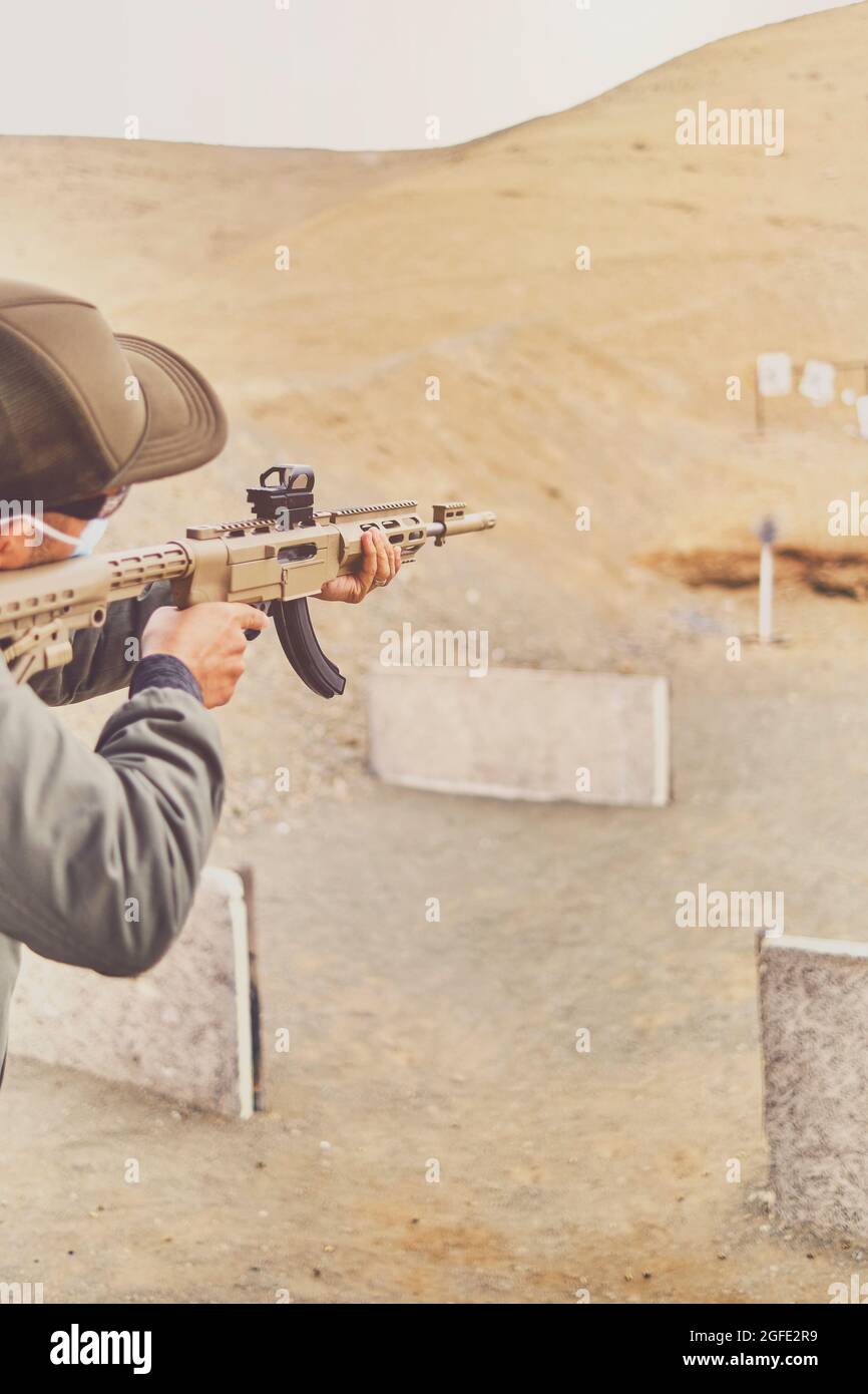 Men practicing shooting with a assault rifle at target. Selective Focus Stock Photo