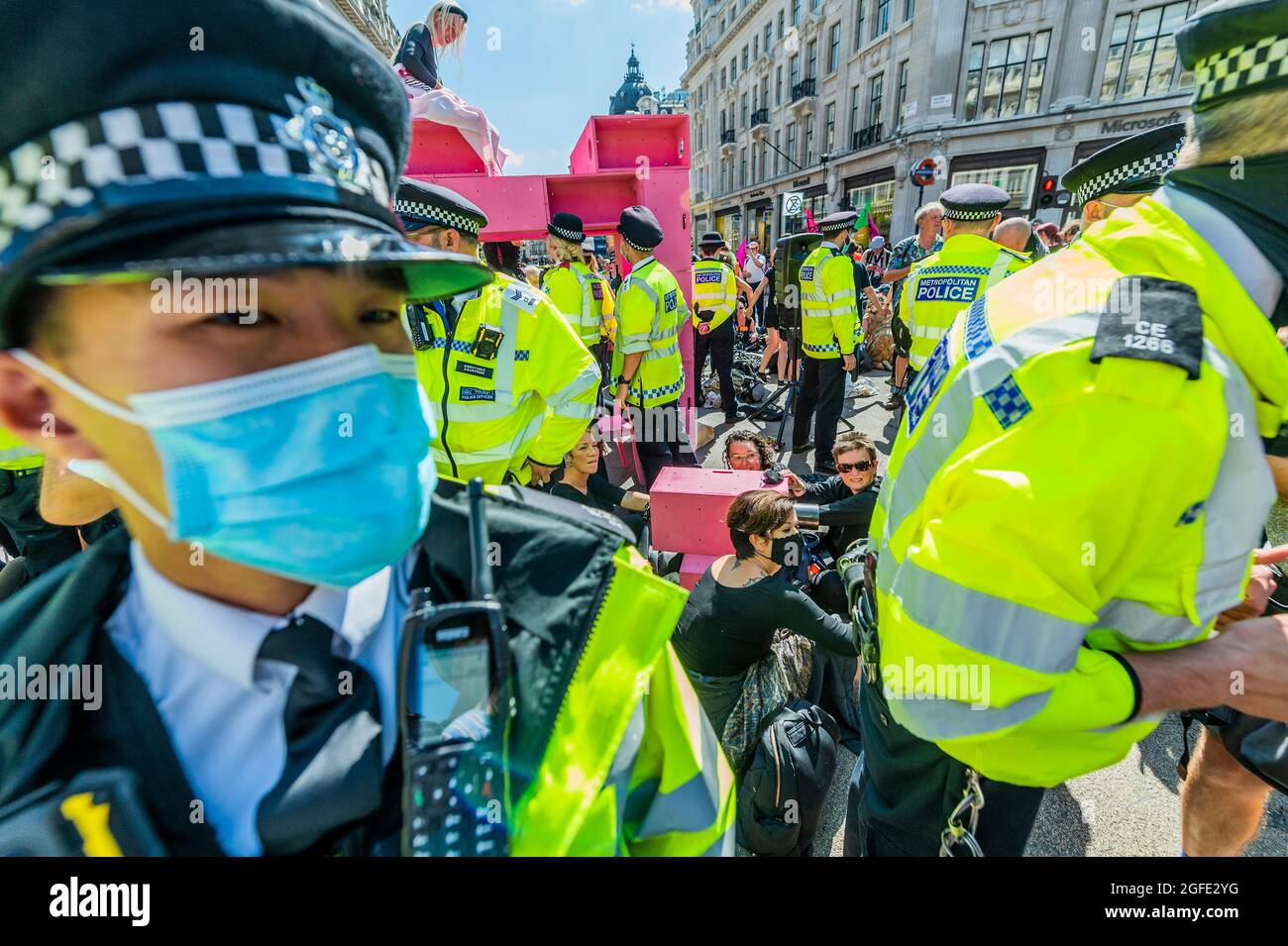 London, UK. 25th Aug, 2021. The police move in aggressively as Rebels occupy Oxford Circus and quickly build a pink structure to block the junction - Extinction Rebellion continues two weeks of protest, under the Impossible Rebellion name, in London. Credit: Guy Bell/Alamy Live News Stock Photo