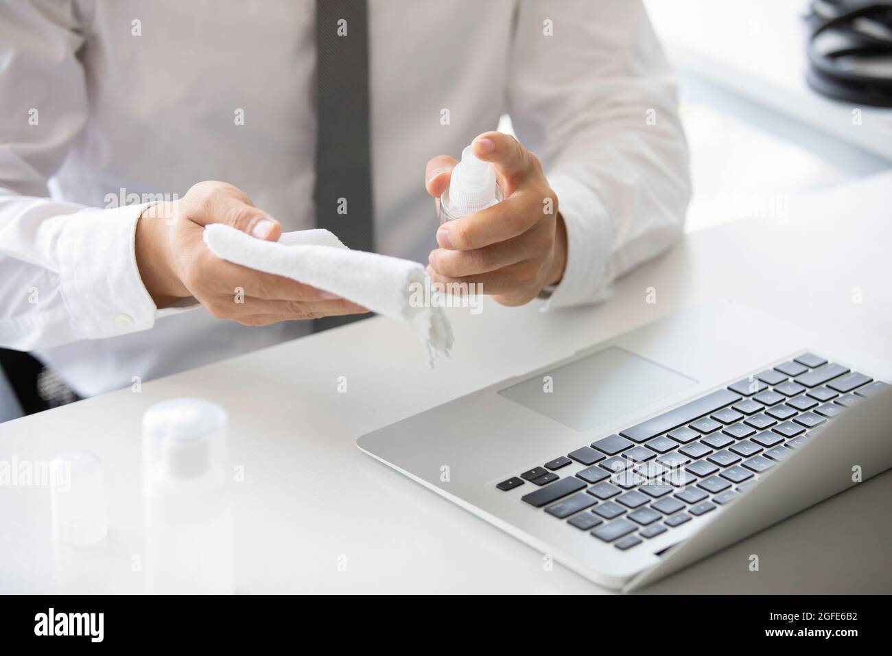 Young businessman using disinfectant in office Stock Photo