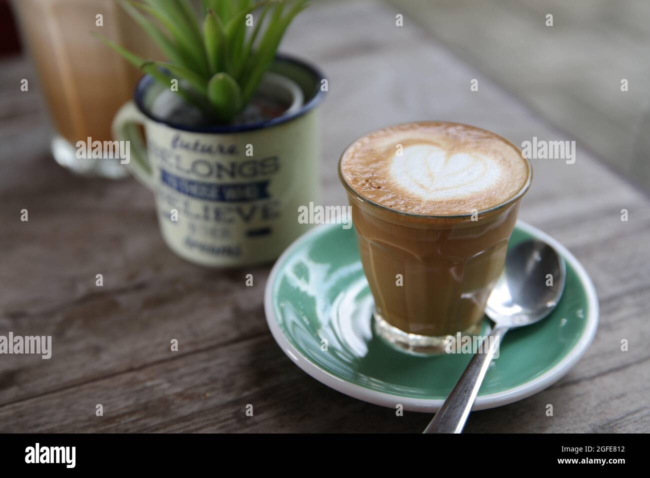 Morning Coffee at coffeeshop. A glass of latte on the table. Stock Photo
