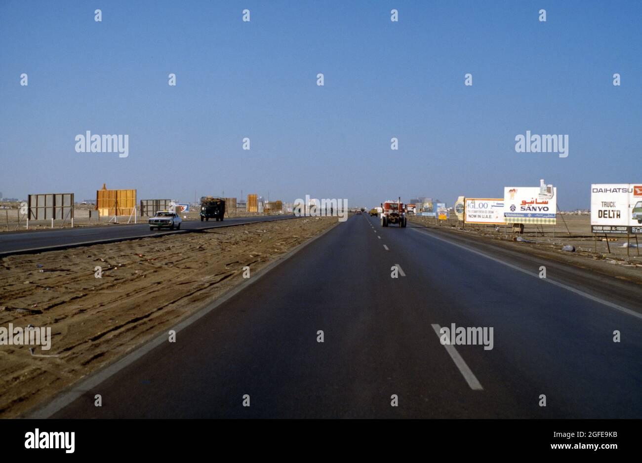 Rubbish in Scrub Desert and Advertising Hoarding alongside Sharjah to Dubai Road Sharjah UAE Stock Photo