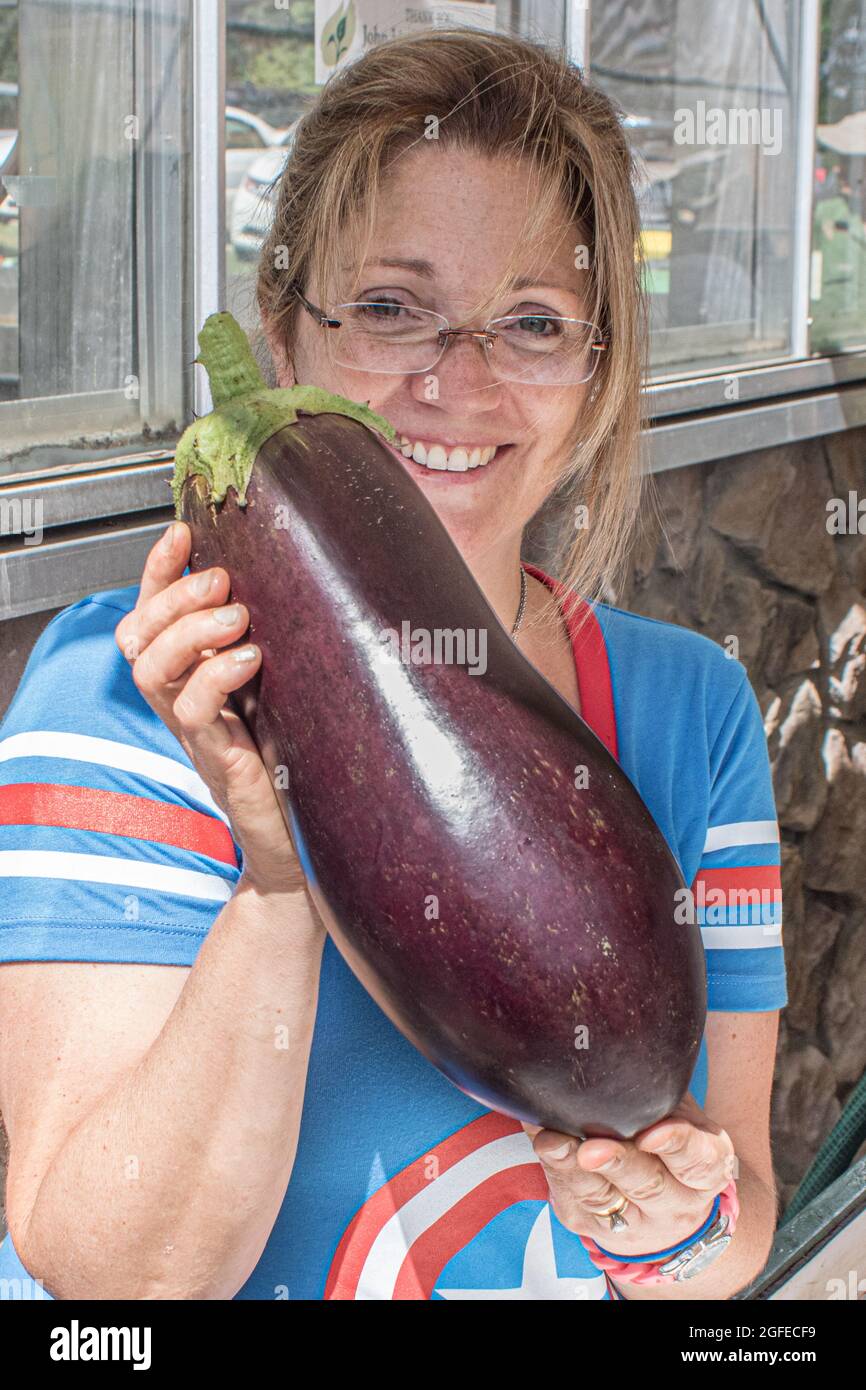 A woman holding a very large eggplant Stock Photo Alamy