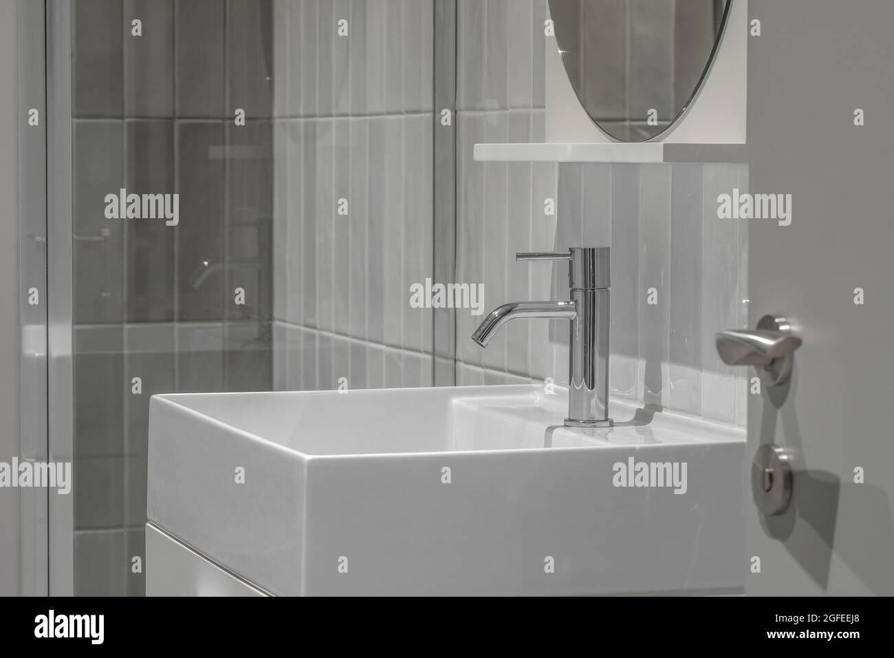 Modern furnished  minimalist bathroom light grey interior design with metro style grey tiles Stock Photo
