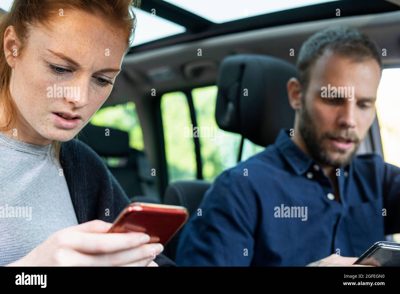 Anxious young couple using smart phones Stock Photo