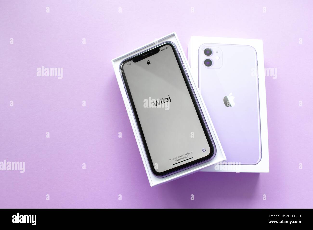 Moscow, Russia, May 2021: A new iPhone 12 model of violet color in an open branded box on a lilac background. On the iPhone screen, a welcome in Polis Stock Photo