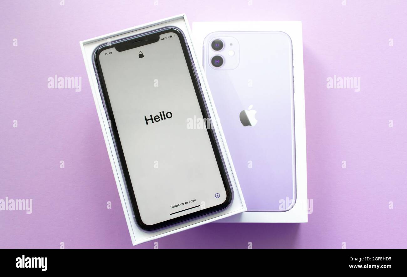 Moscow, Russia, May 2021: A new iPhone 12 model of violet color in an open branded box on a lilac background. On the iPhone screen, a welcome in Engli Stock Photo