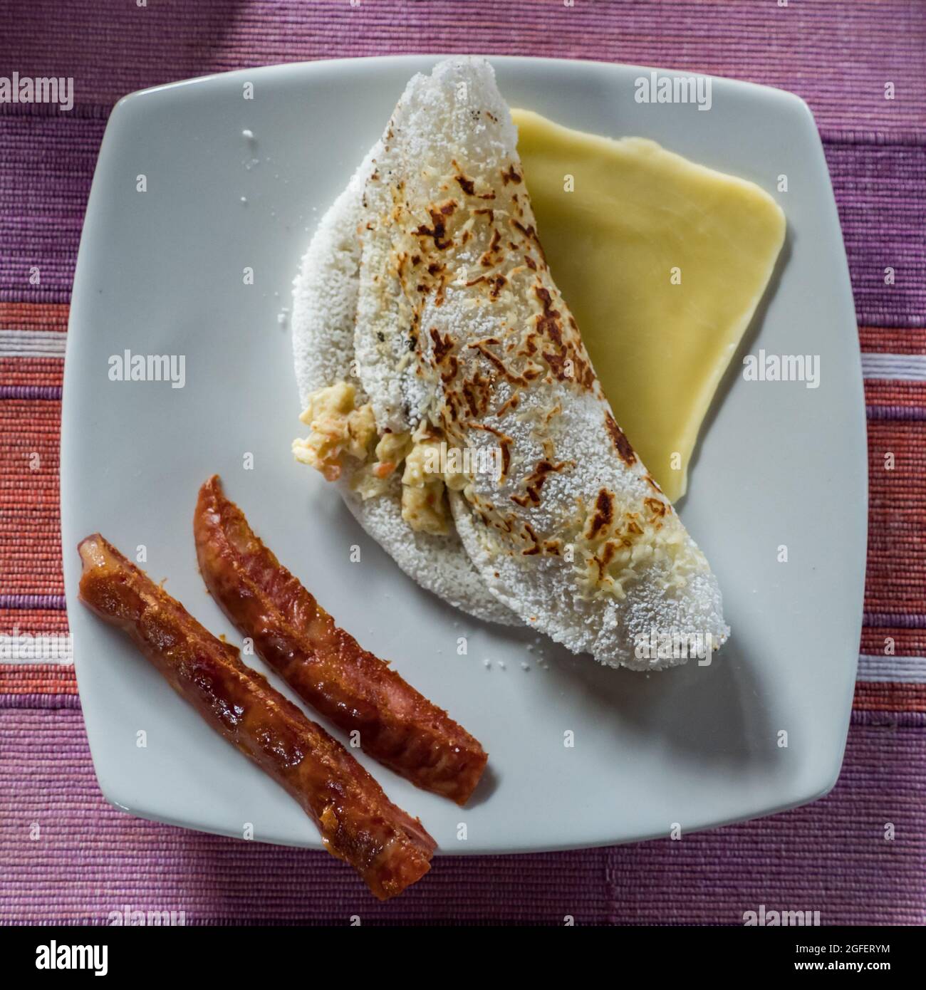 Typical colombian breakfast arepa with fried eggs, slice of cheese