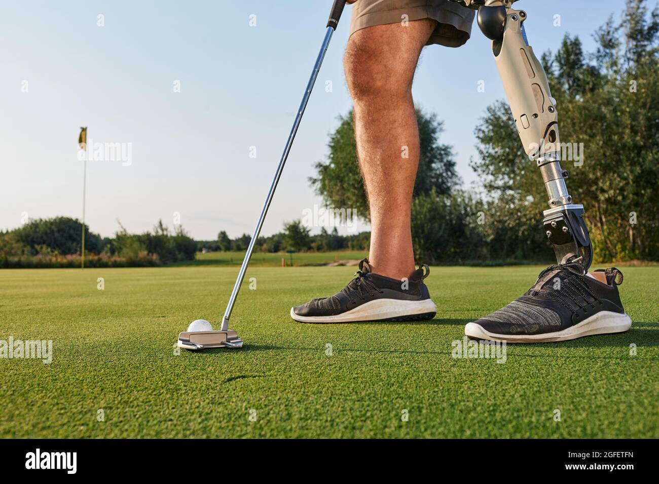 Professional golfer with prosthetic leg hitting with putter on golf