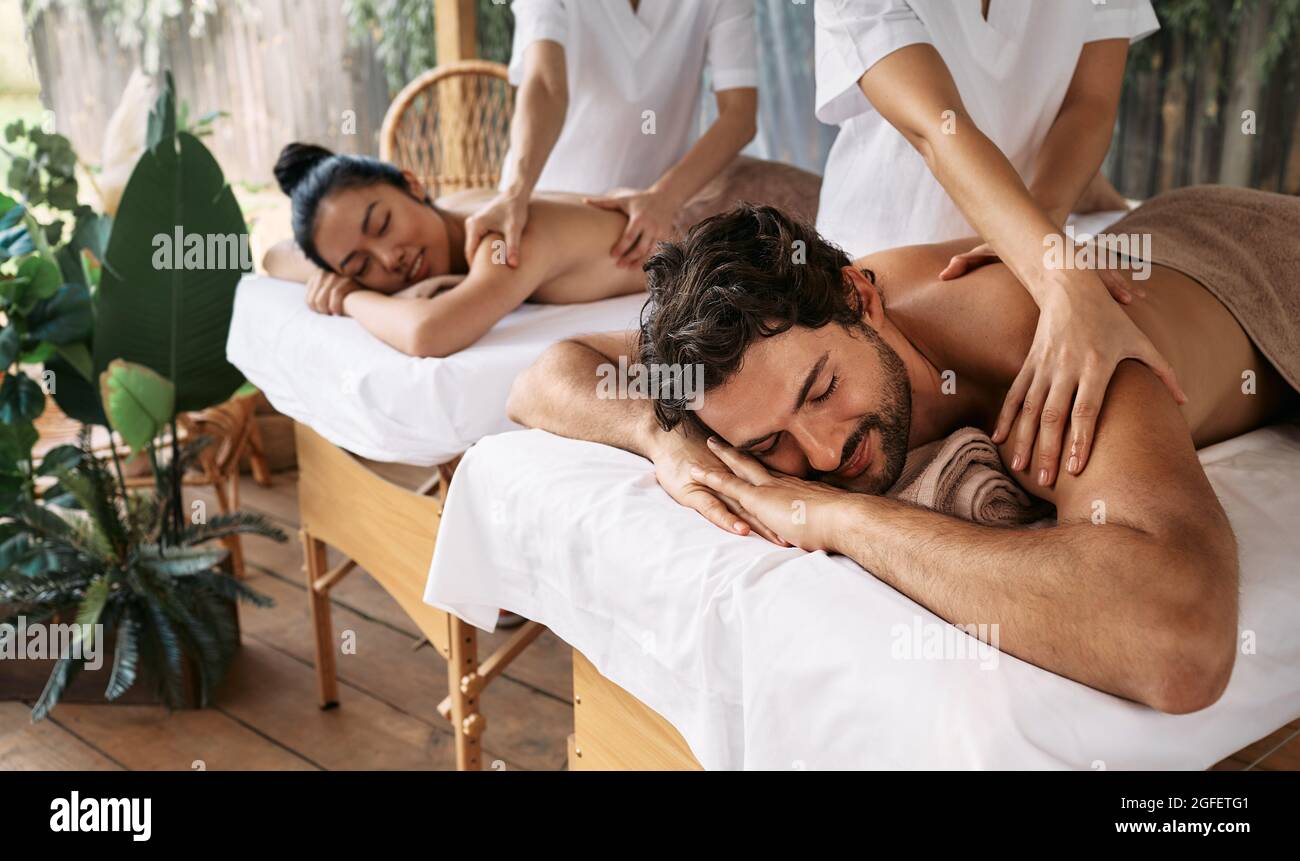 Couple massage at spa resort. Beautiful couple getting a back massage  outdoor, romantic weekend and relax Stock Photo - Alamy