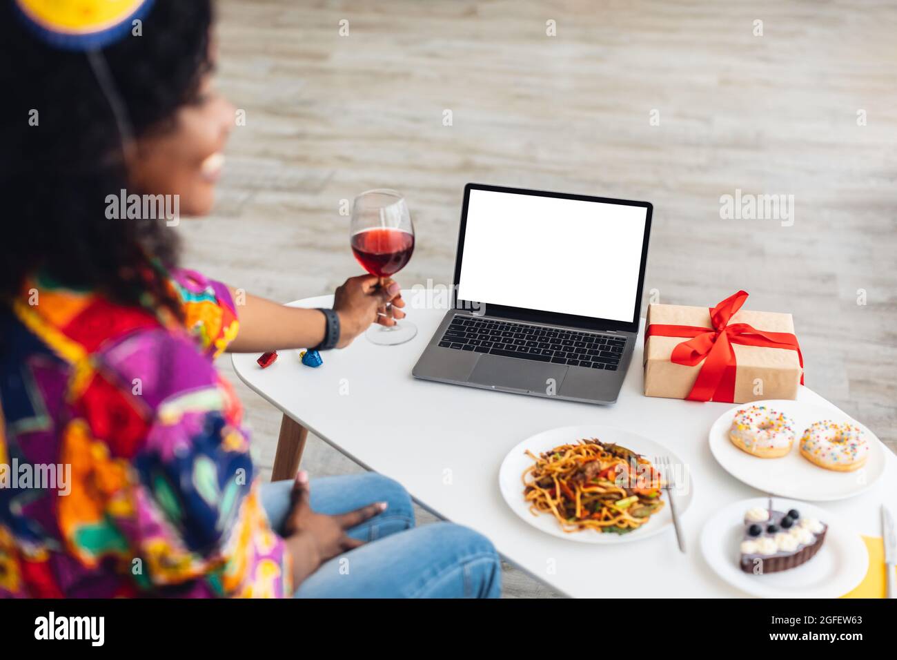 Black Female At Laptop With Empty Screen Celebrating Birthday Indoor Stock Photo