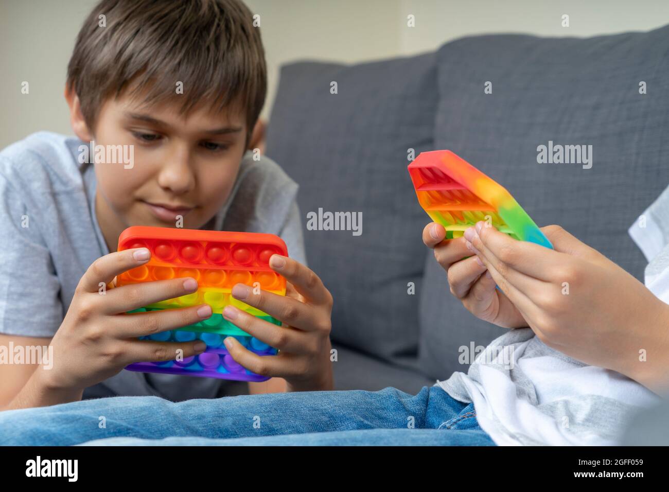 Kids playing with rainbow popit fidget toys at home. Push pop it