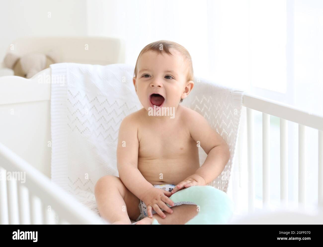 Cute baby sitting in the bed Stock Photo