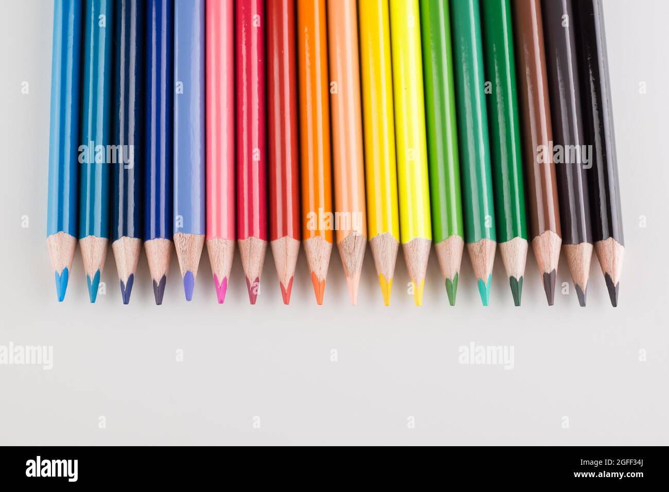 set of colored pencils lined up hardly on a white background Stock Photo