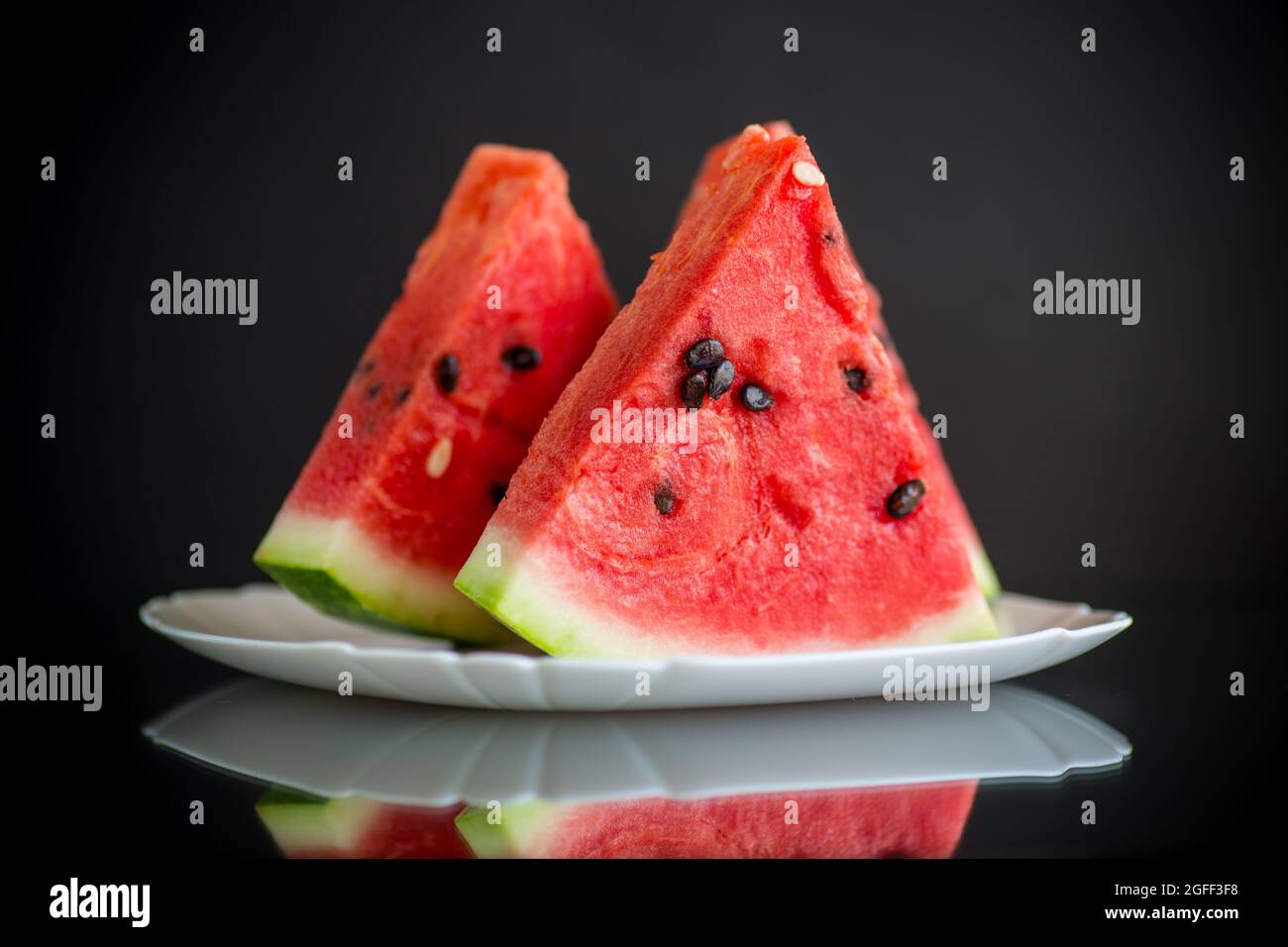 pieces of fresh ripe red watermelon on black background Stock Photo