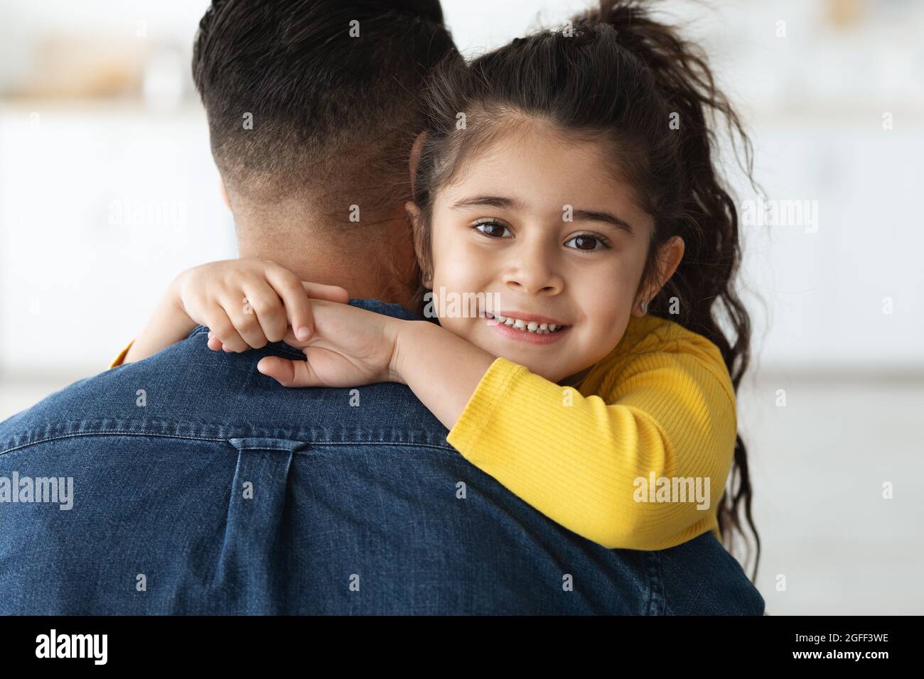 Closeup Shot Of Adorable Little Middle Eastern Girl Cuddling Her Daddy Stock Photo
