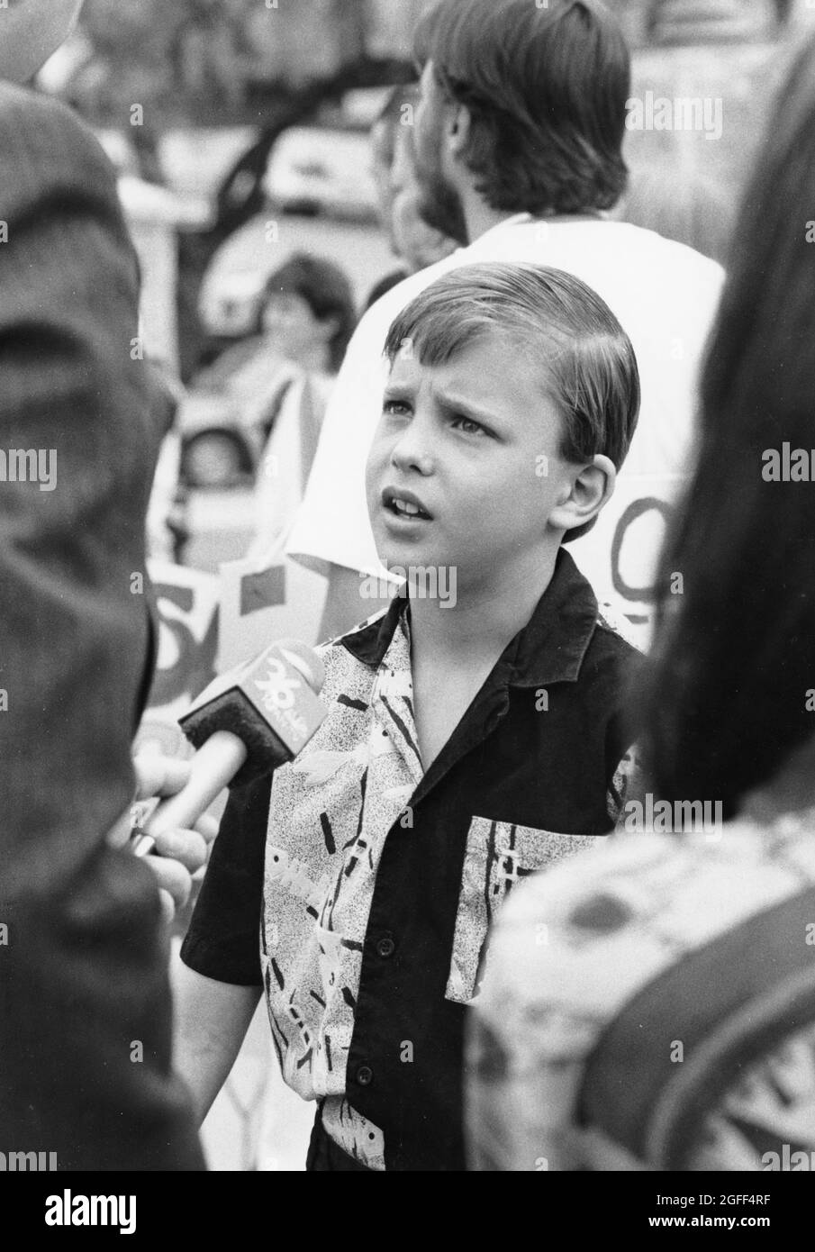 Austin Texas USA, circa 1994: TV reporter interviews young boy  about a  policy regarding hair length in school. ©Bob Daemmrich Stock Photo