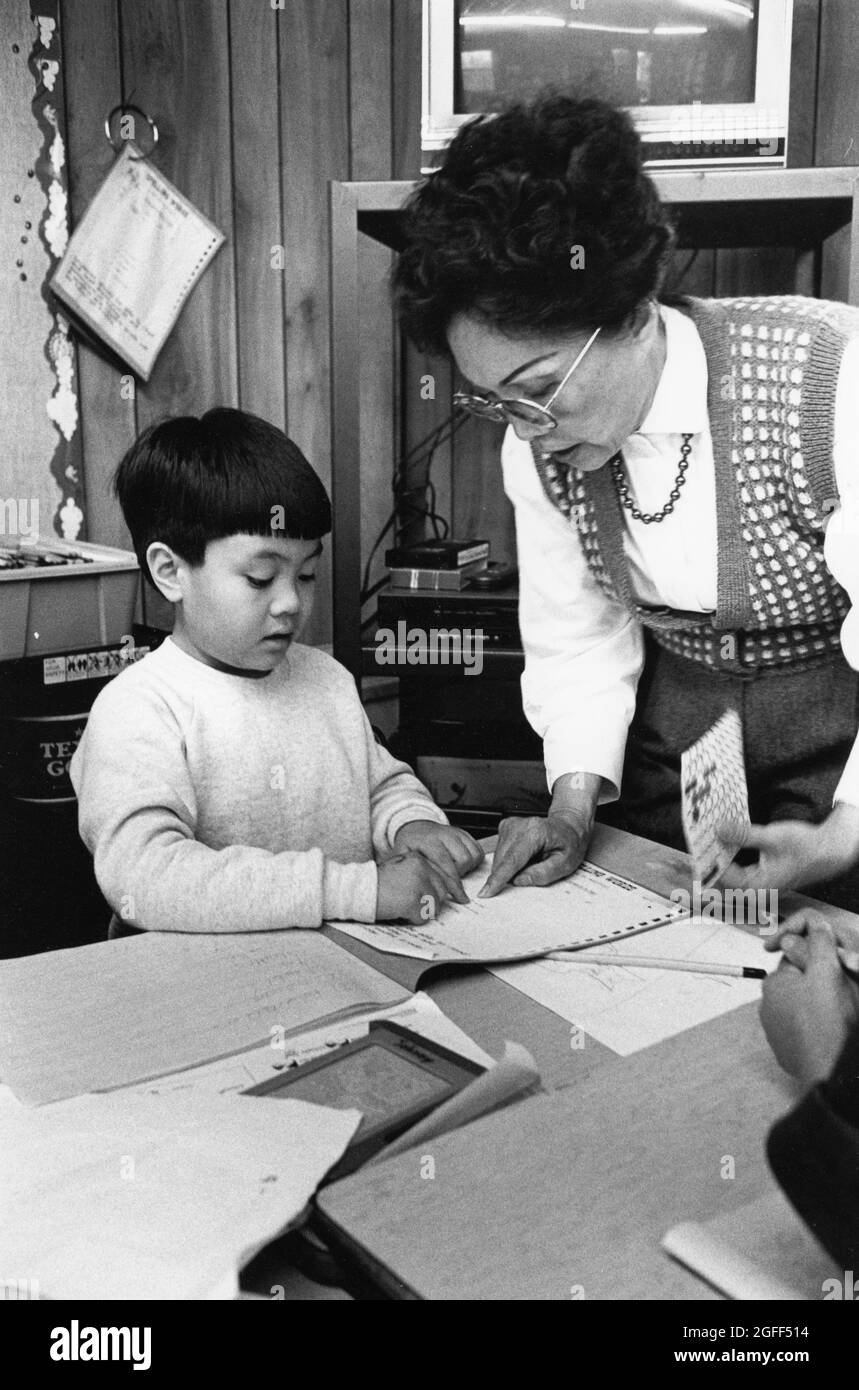 Austin Texas USA, 1993: Vietnamese-American teacher works with young Vietnamese-American student in bilingual classroom for 2nd through 5th graders at Walnut Creek Elementary. FILE EP-0388   ©Bob Daemmrich Stock Photo