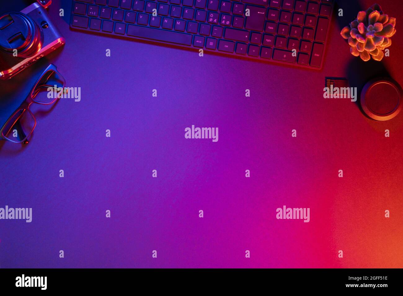 Overhead view of computer keyboard with camera on illuminated table Stock Photo