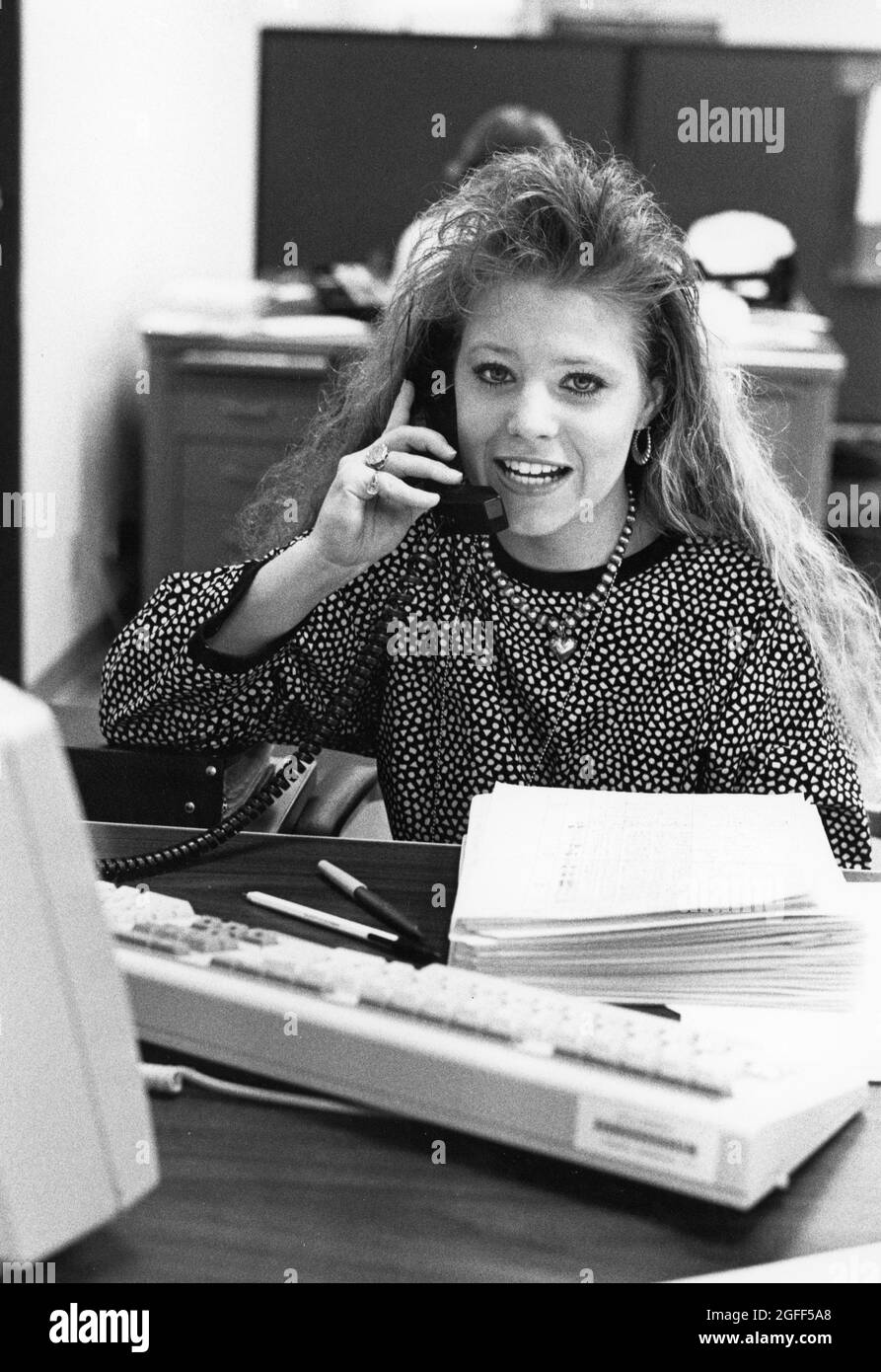 Austin Texas 1990: Data entry clerk talks on phone at United States Census regional processing center. ©Bob Daemmrich Stock Photo