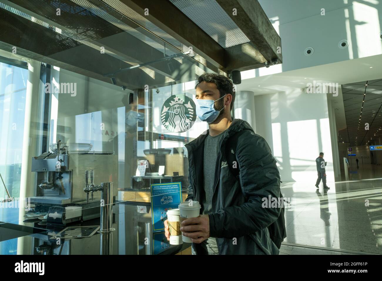 Arnavutkoy, Istanbul, Turkey - 03.08.2021: a handsome man with protective mask buying Starbucks coffee in Istanbul Airport before departure time Stock Photo