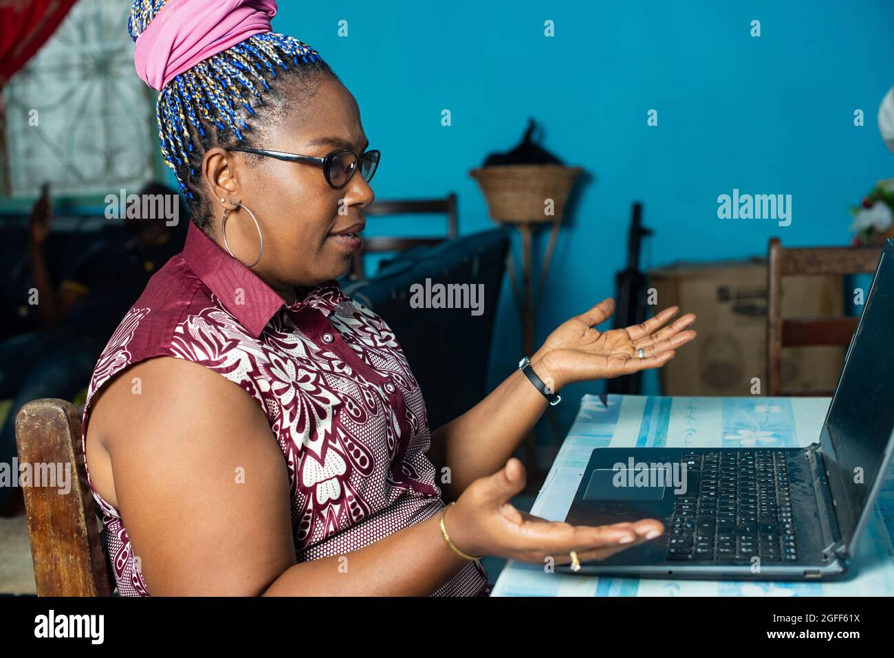 beautiful, african woman sitting at a table using laptop expression ...